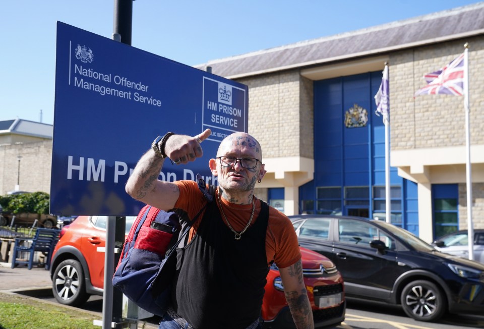 a man standing in front of a hm prison service sign