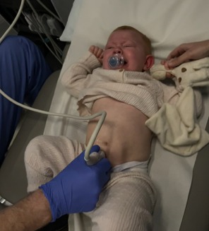 a baby with a pacifier in his mouth is being examined by a doctor