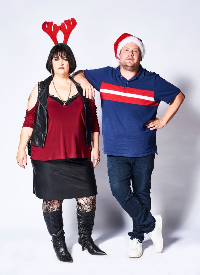 a man wearing a santa hat stands next to a woman wearing reindeer antlers