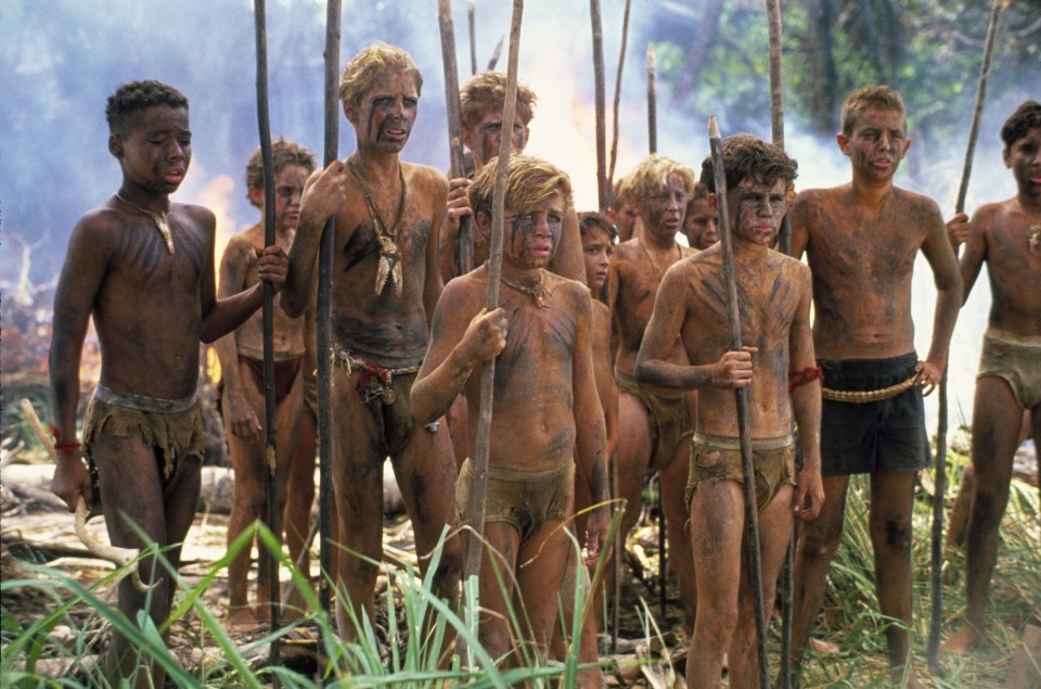 a group of boys with their faces painted are standing in the grass