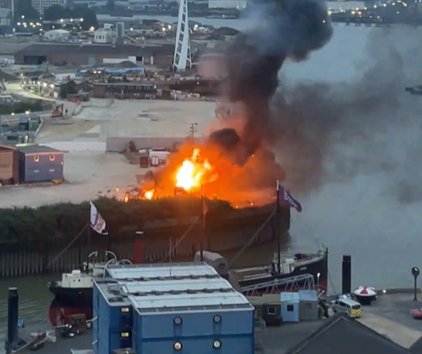 a large fire is going on in a harbor