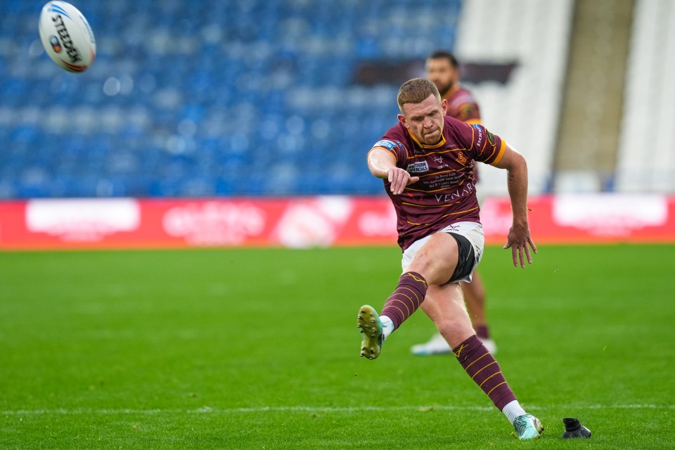 a man kicking a rugby ball that says ' steelers ' on it