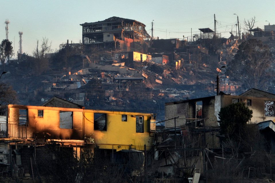 Aerial view of the aftermath of a fire at the hills in Viña del Mar, Chile on February 3, 2024. The region of Valparaoso and Viña del Mar, in central Chile, woke up on Saturday with a partial curfew to allow the movement of evacuees and the transfer of emergency equipment in the midst of a series of unprecedented fires, authorities reported. (Photo by Javier TORRES / AFP) (Photo by JAVIER TORRES/AFP via Getty Images)