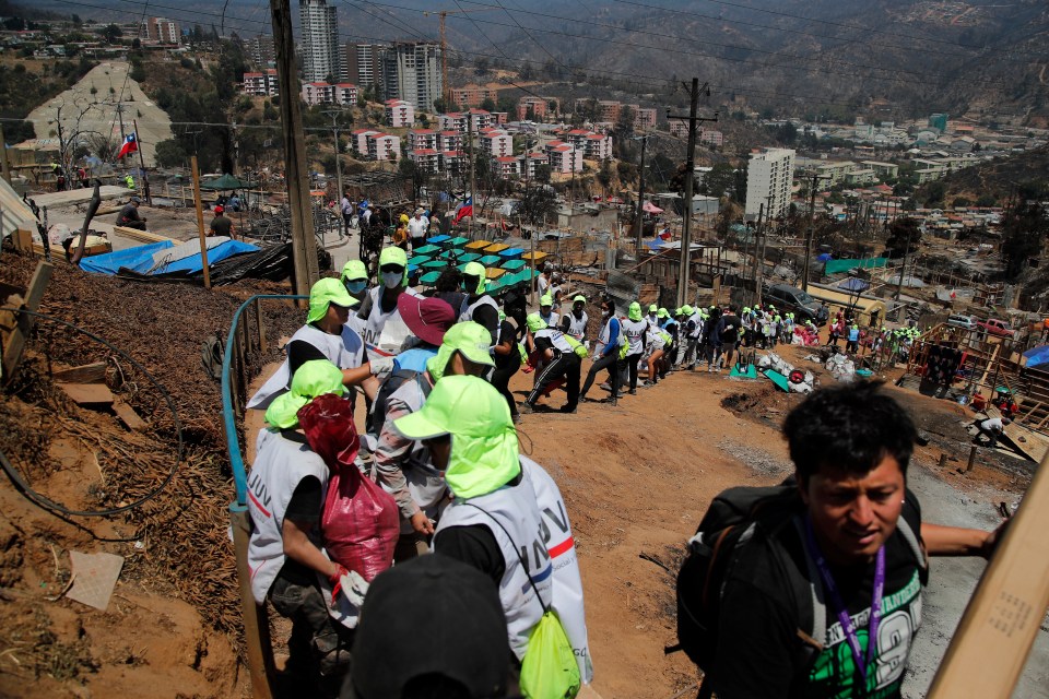 Volunteers deliver community aid to affected residents after a forest fire in the Poblacion Monte Sinai neighborhood in Viña Del Mar, Chile, on February 7, 2024. Firefighters said Wednesday they had extinguished all wildfires in Chile's coastal region of Valparaiso, where flames razed entire communities and left 131 dead. (Photo by Javier TORRES / AFP) (Photo by JAVIER TORRES/AFP via Getty Images)