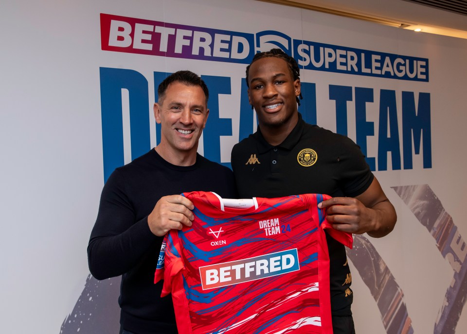 a man holding a red shirt that says betfred on it