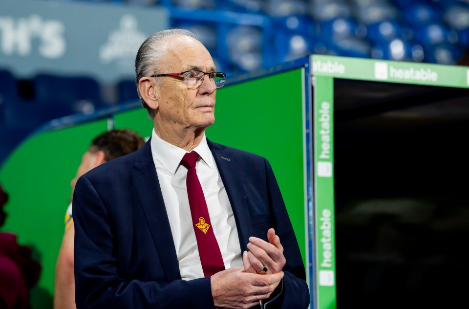 a man in a suit and tie stands in front of a green sign that says heatable