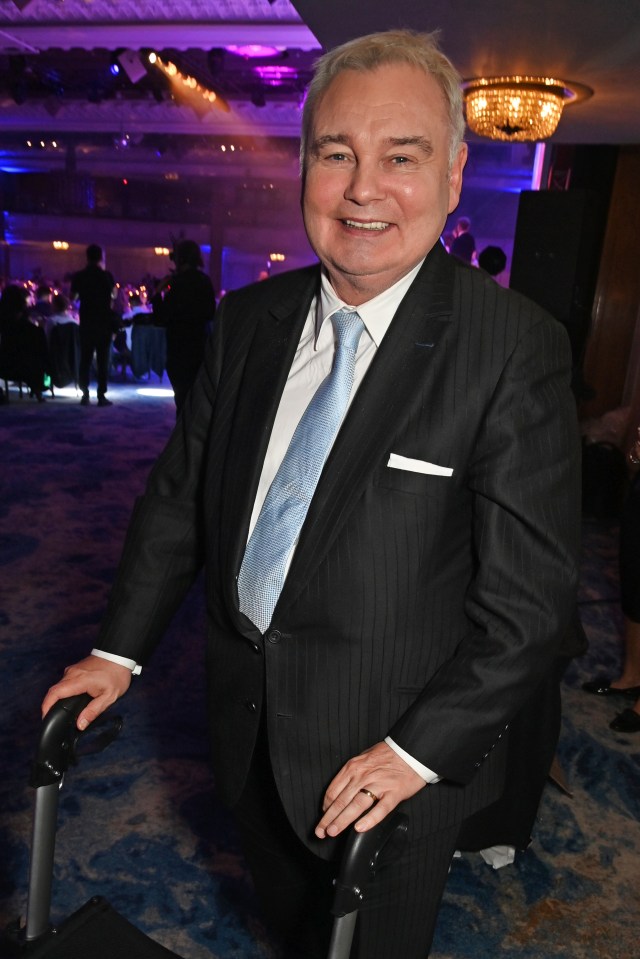 a man in a suit and tie is leaning on a wheelchair