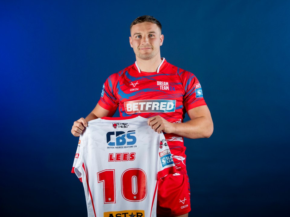 a man holding up a jersey with the number 10 on it