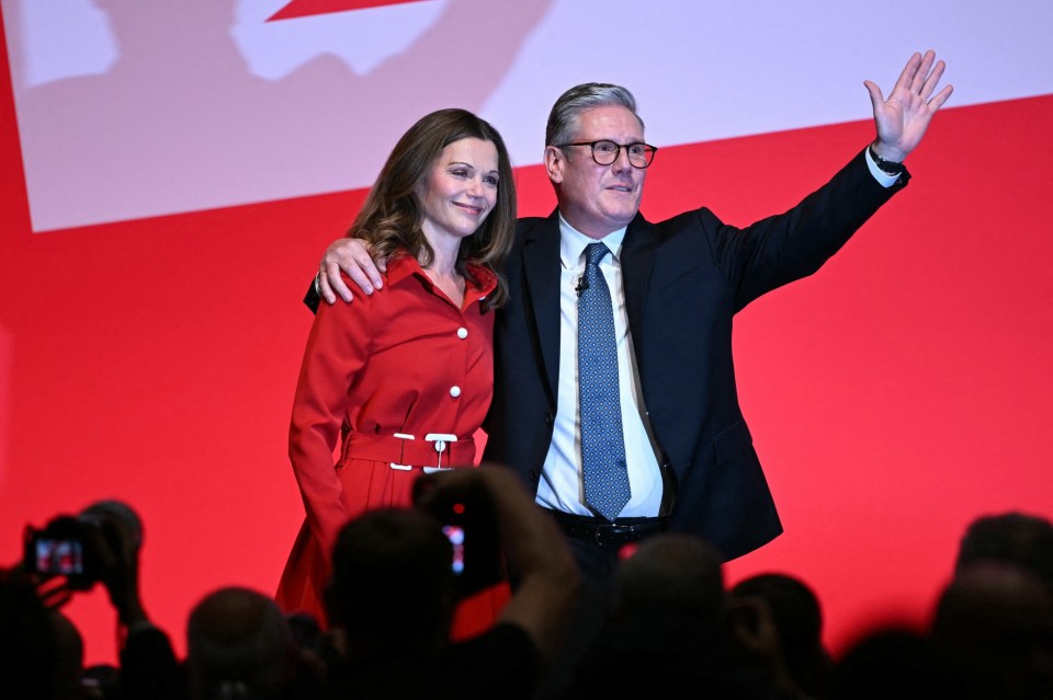 a man in a suit and tie stands next to a woman in a red dress