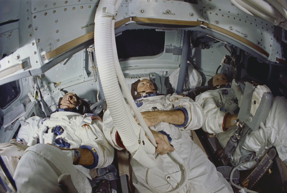 a group of astronauts are sleeping in a space shuttle