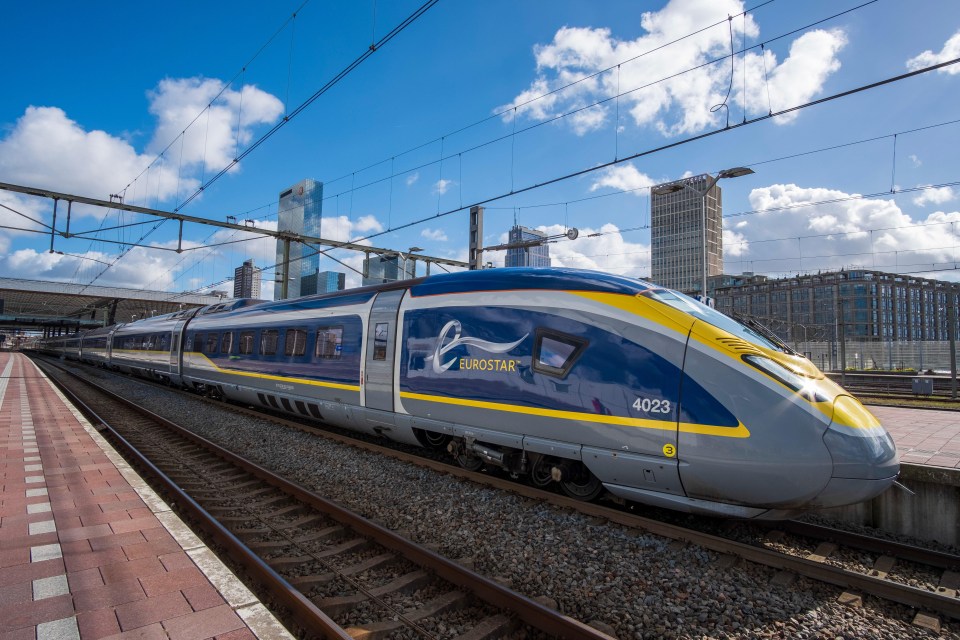 a blue and yellow eurostar train is on the tracks