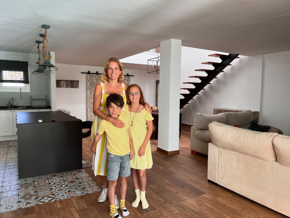 a woman and two children pose for a picture in a living room