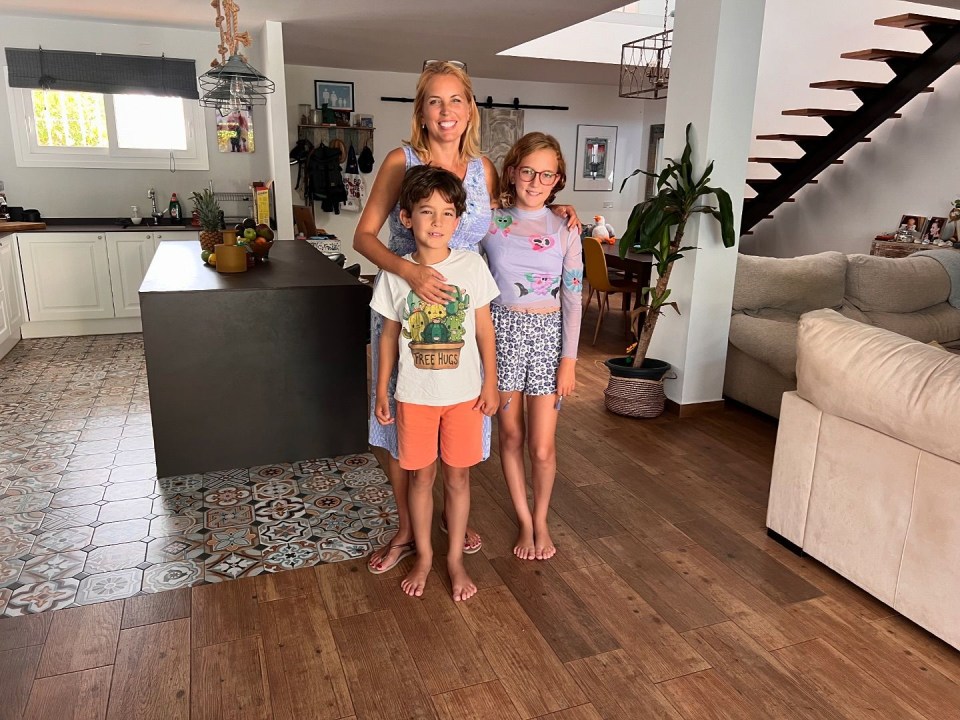 a woman and two children pose for a picture in a living room