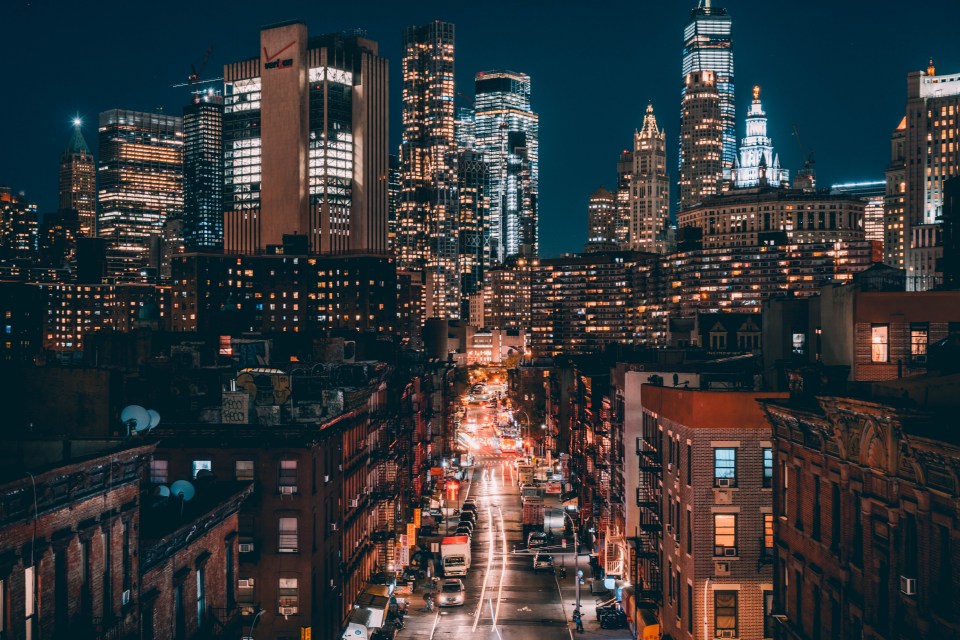 a city street at night with a verizon building in the background