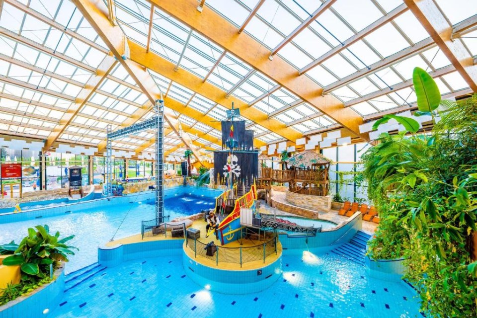 a large indoor pool with a pirate ship in the middle