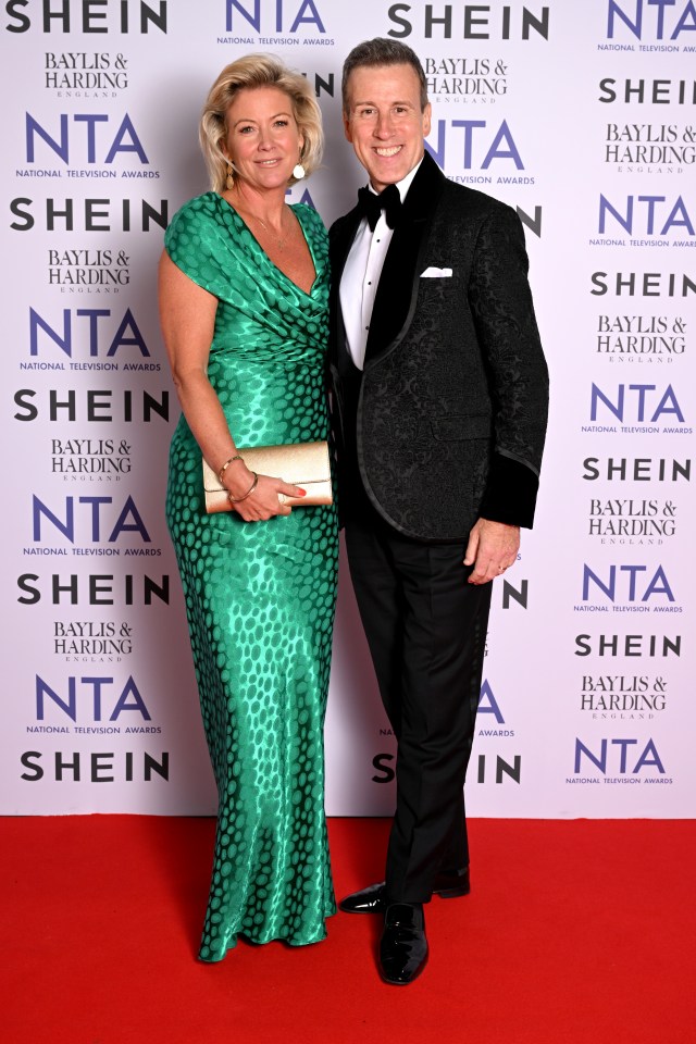 a woman in a green dress and a man in a tuxedo pose for a picture in front of a wall that says shein