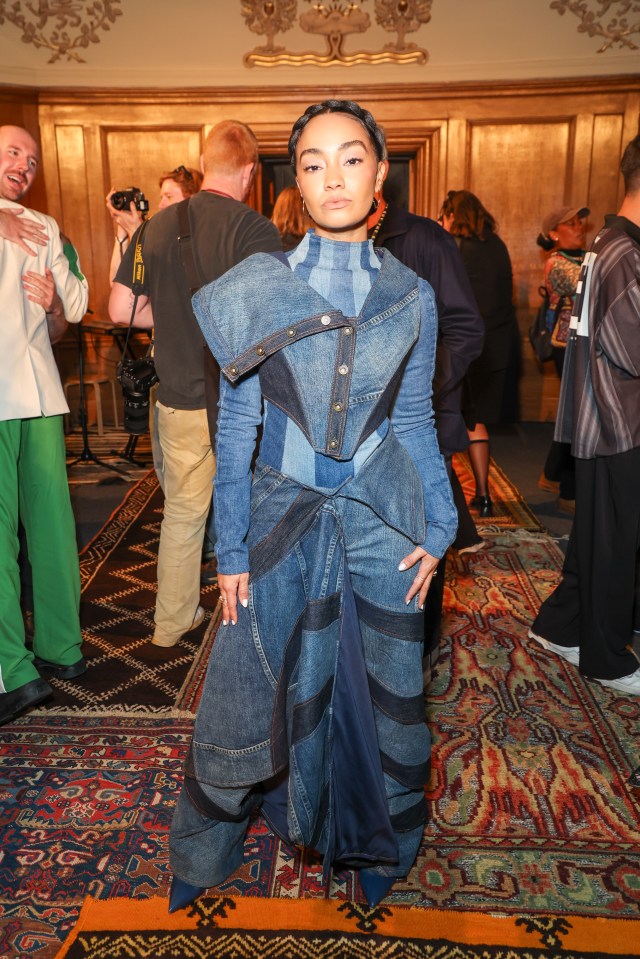 a woman in a denim outfit stands on a rug