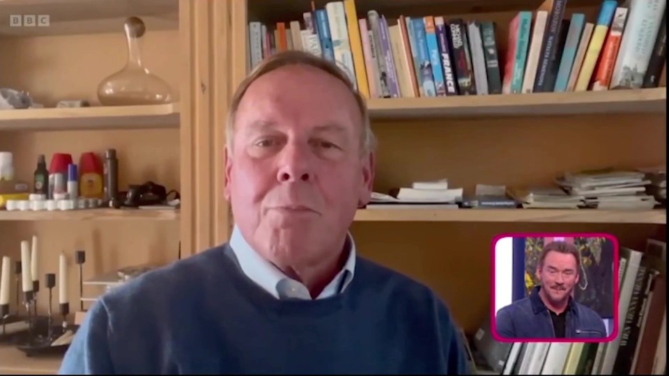 a man in front of a bookshelf with a bbc logo