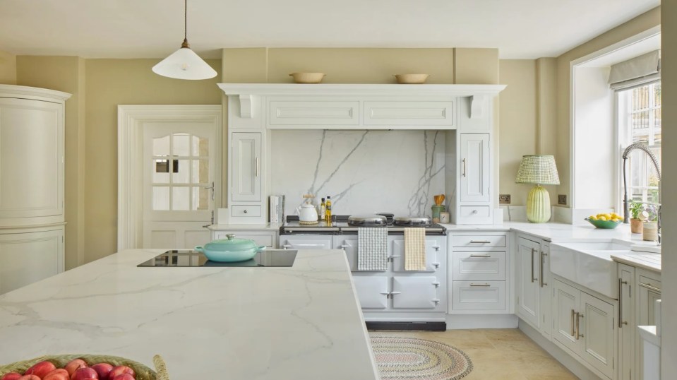 a kitchen with white cabinets and a white stove top oven