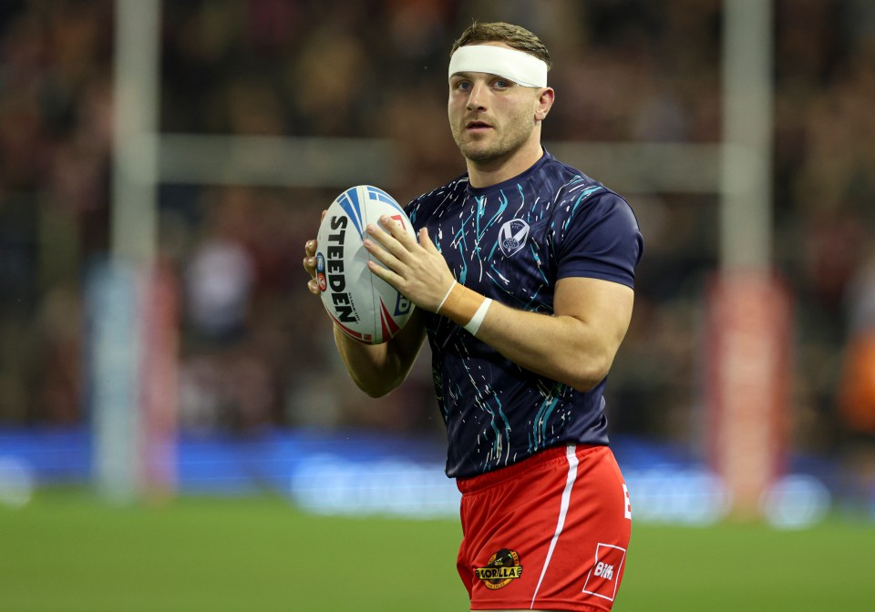 a man holding a rugby ball that says steeden on it