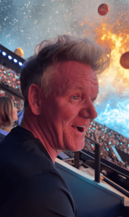 a man sitting in a stadium with his mouth open