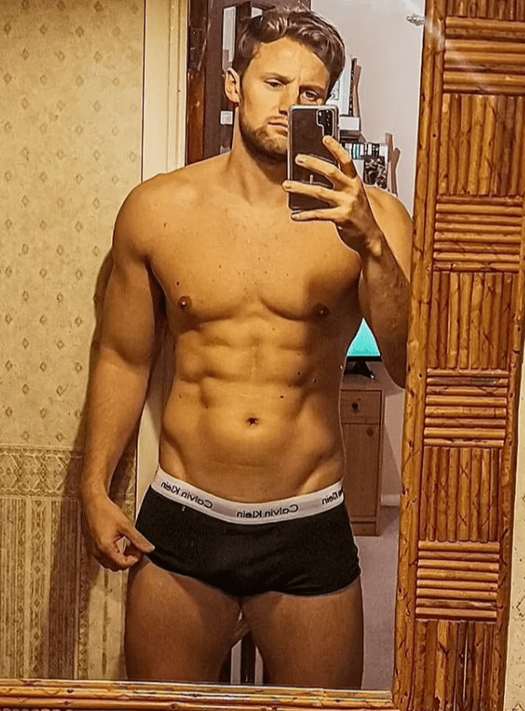 a shirtless man taking a selfie in front of a mirror wearing calvin klein underwear