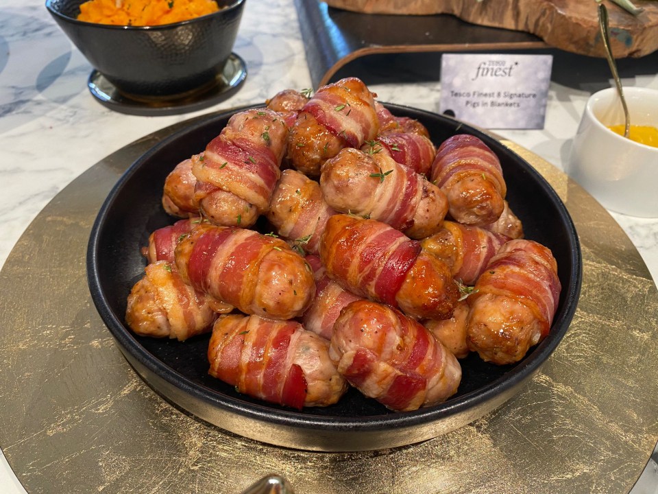 a plate of bacon wrapped sausages from the finest