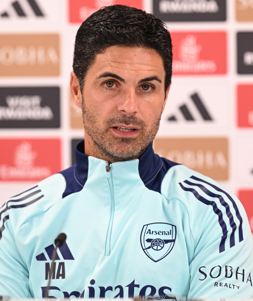 a man with a beard wears a blue arsenal shirt