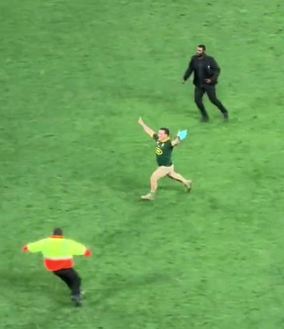 a man in a green shirt is running on a soccer field .