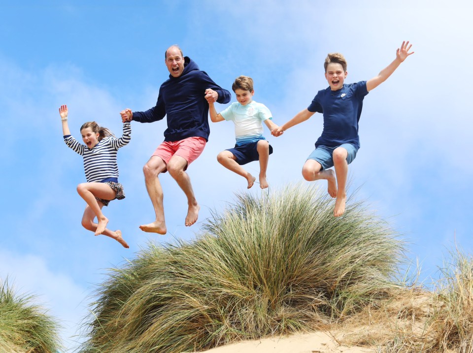 a family is jumping in the air while holding hands