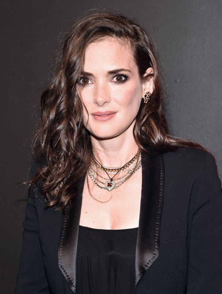 a woman wearing a black jacket and a necklace