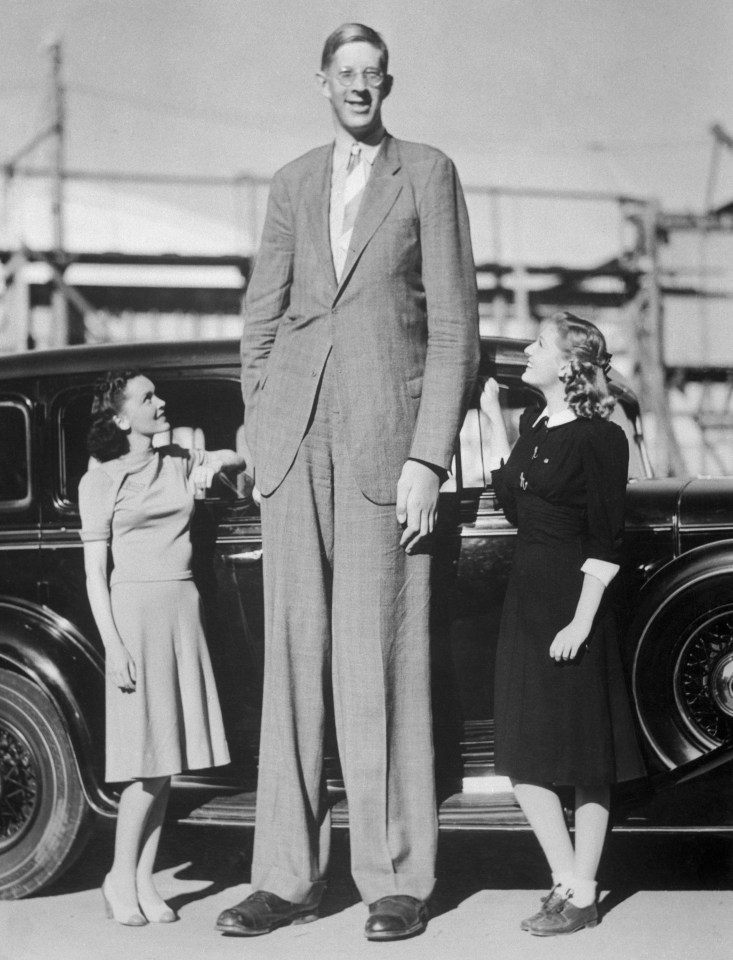 a man in a suit and tie is standing next to two women