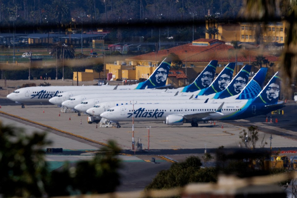 a row of alaska planes are parked on the tarmac