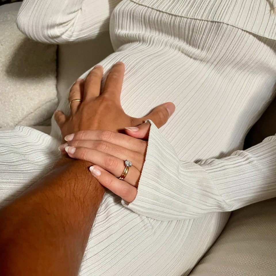 a man and a woman pose for a picture in a living room