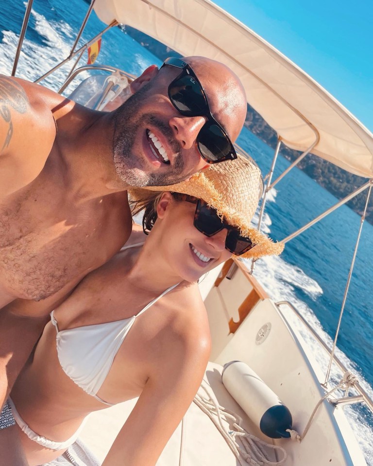 a man and a woman are on a boat and the woman is wearing a bikini top