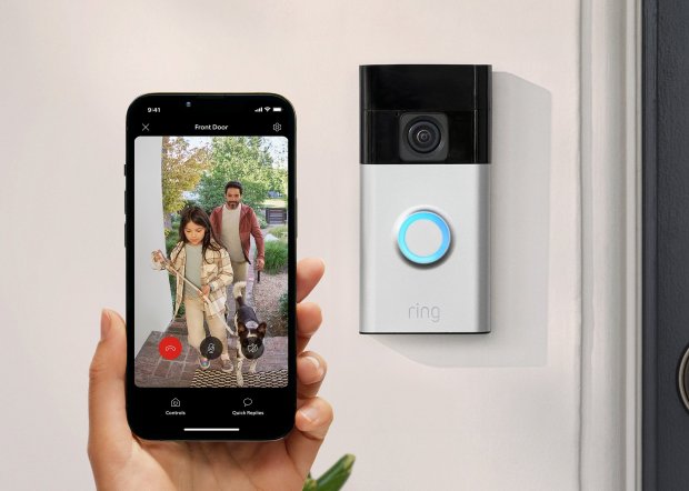 a person is holding a phone in front of a ring doorbell