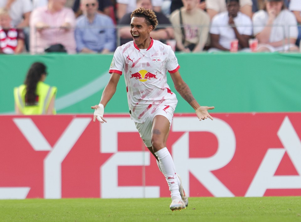 a soccer player wearing a red bull jersey celebrates a goal