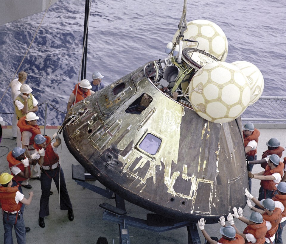 a group of men in hard hats are working on a space ship