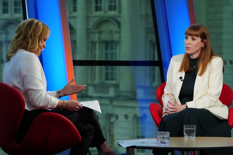 two women are sitting at a table talking to each other