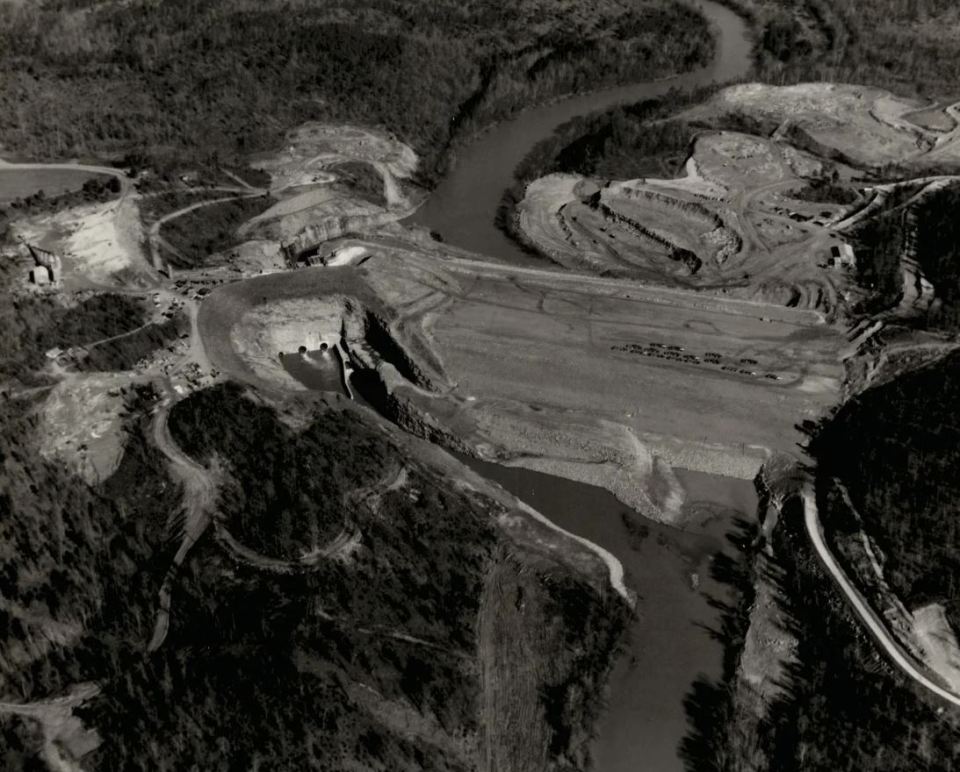 a black and white photo of a river and a dam