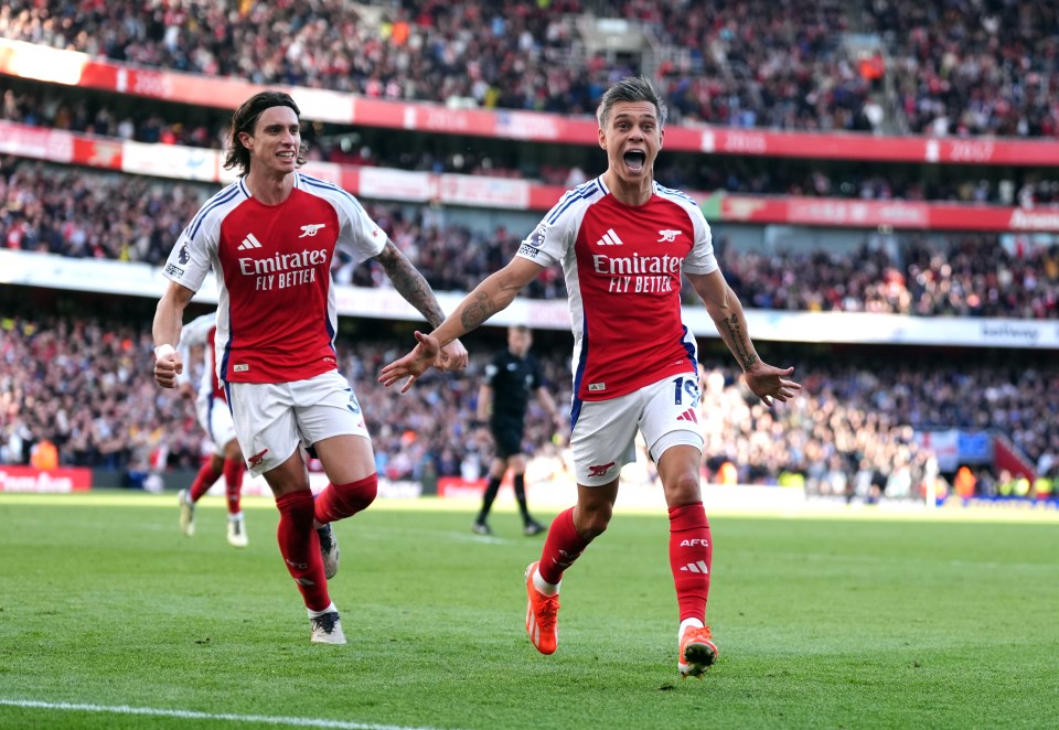 two soccer players wearing emirates fly better jerseys celebrate