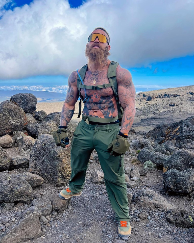 a man with a beard is standing on a rocky hillside