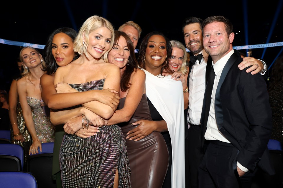 a group of people posing for a picture in front of a sign that says national television