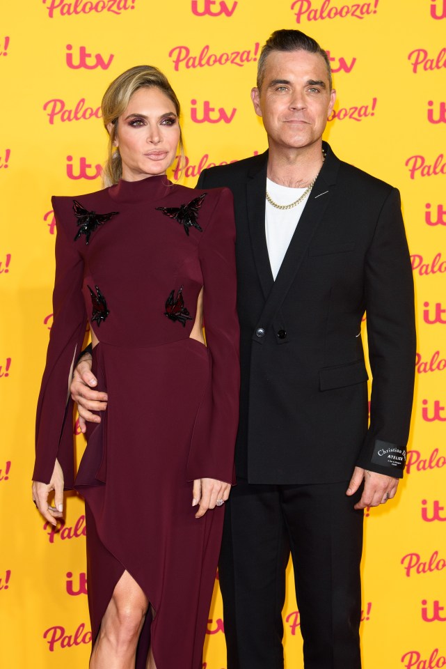 a man and a woman stand on a yellow carpet that says palooza