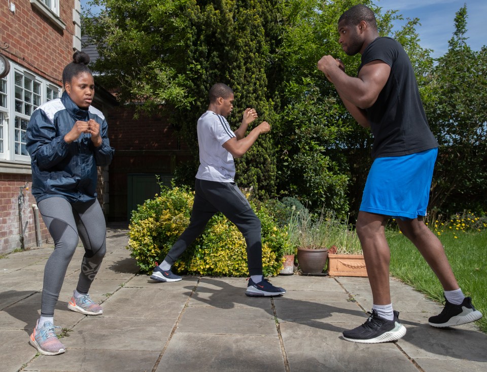 a man in blue shorts and a woman in a blue jacket are boxing