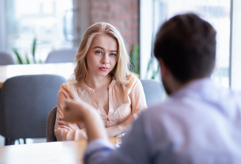 a man and a woman are sitting at a table having a conversation