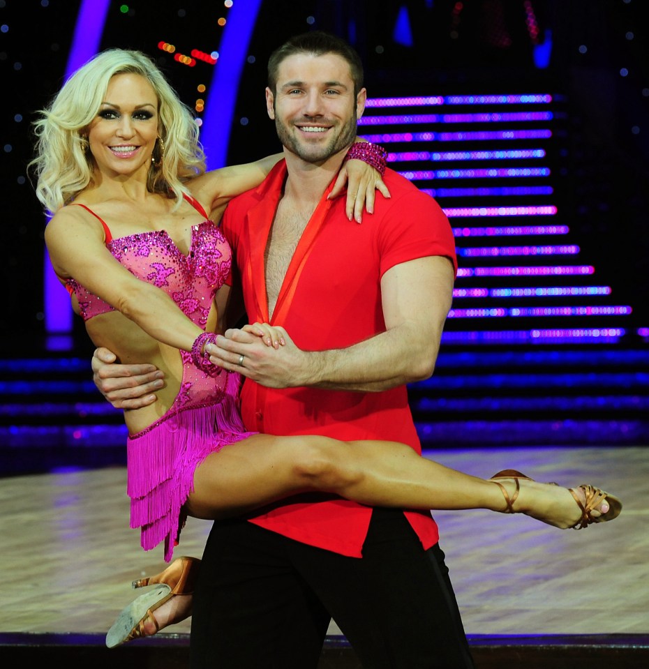 a man is holding a woman in his arms on a dance floor