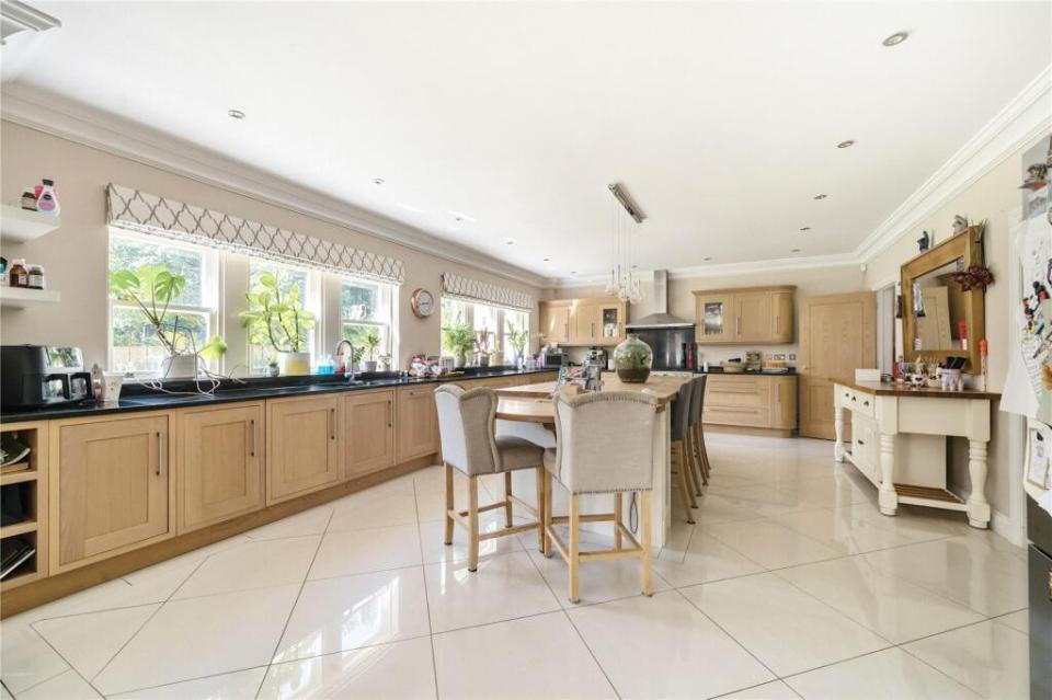 a kitchen with wooden cabinets and white tile floors