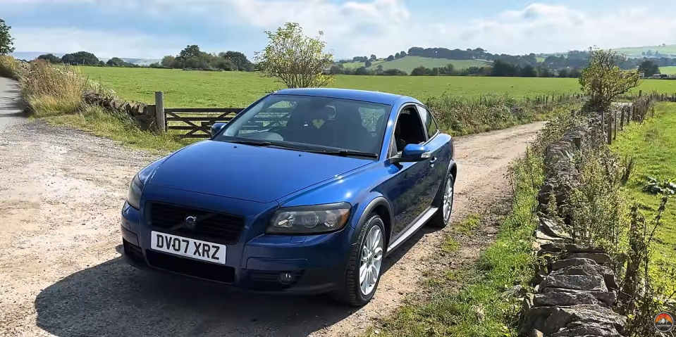 a blue car has a license plate that says dv07 xrz