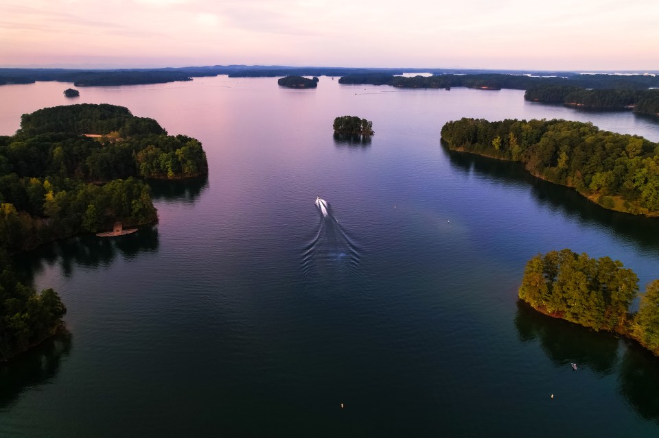 an aerial view of a lake with a boat in it